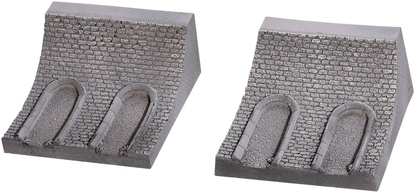 Two model railway bridges made of stone imitation placed side by side, each with two tunnel openings, surrounded by realistic-looking stone structure.