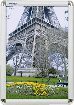 The Eiffel Tower towers over a park with flowers and bare trees. Several people are visible below, observing the landmark.