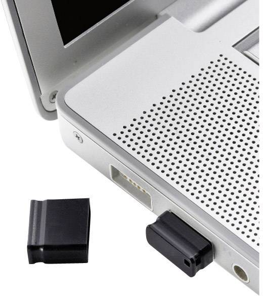 A black USB stick is plugged into a laptop. The cap of the USB stick is lying next to the laptop on the table.
