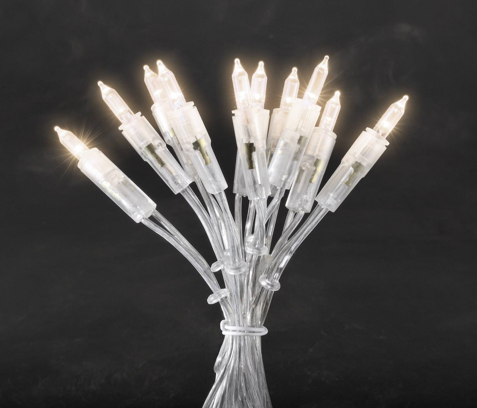 A bundle of warm white LED lights on a transparent cable glows against a black background. Perfect for decorations.