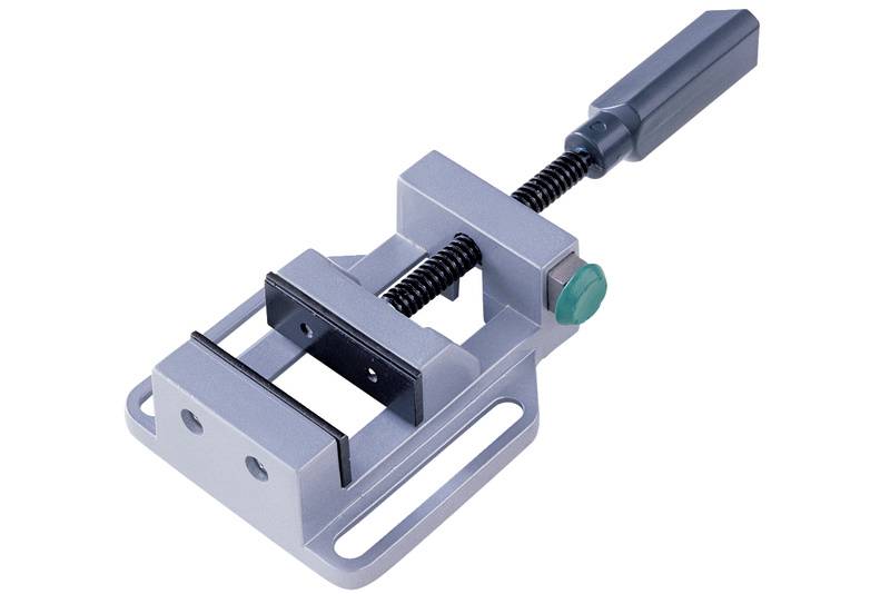 Small bench vice with metal frame and rotary handle, suitable for securing small workpieces for precision work in workshops.