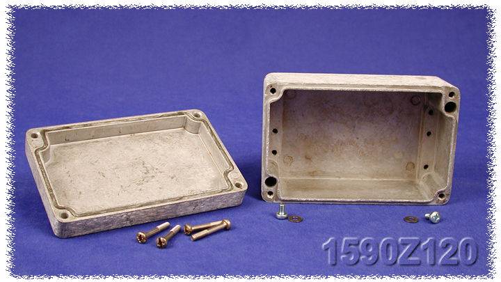 Rectangular metal enclosure with its cover removed, screws and nuts lying in front of it, on a blue background.