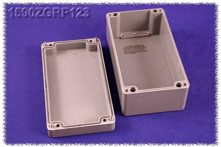 Grey plastic casing, two parts: lid and base, on a purple background. Rectangular shape with screw openings.