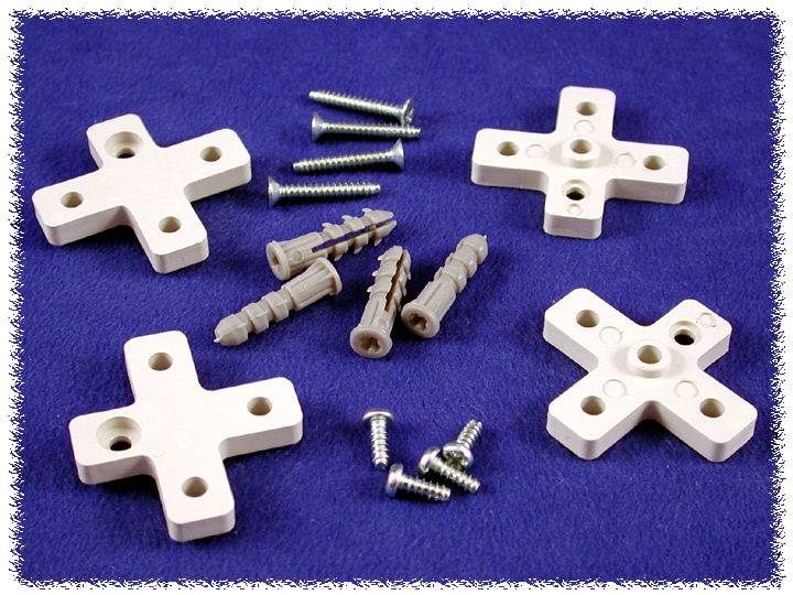 Four white mounting crosses, screws and wall plugs on a blue background. Used for fixing objects to walls.