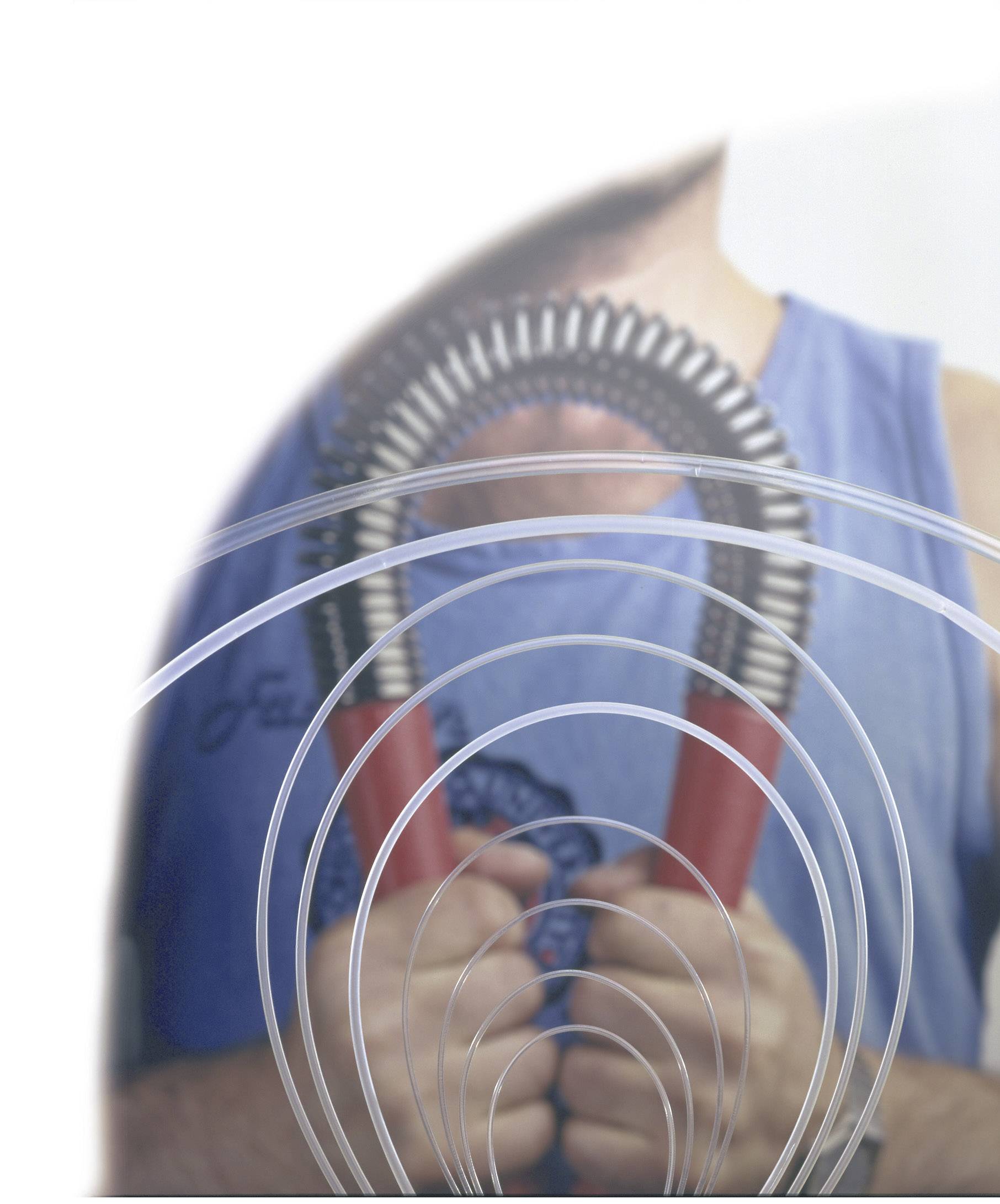 Man in blue tank top holds red pen-grip trainer in front of his chest, blurred image with circular lines in the foreground.
