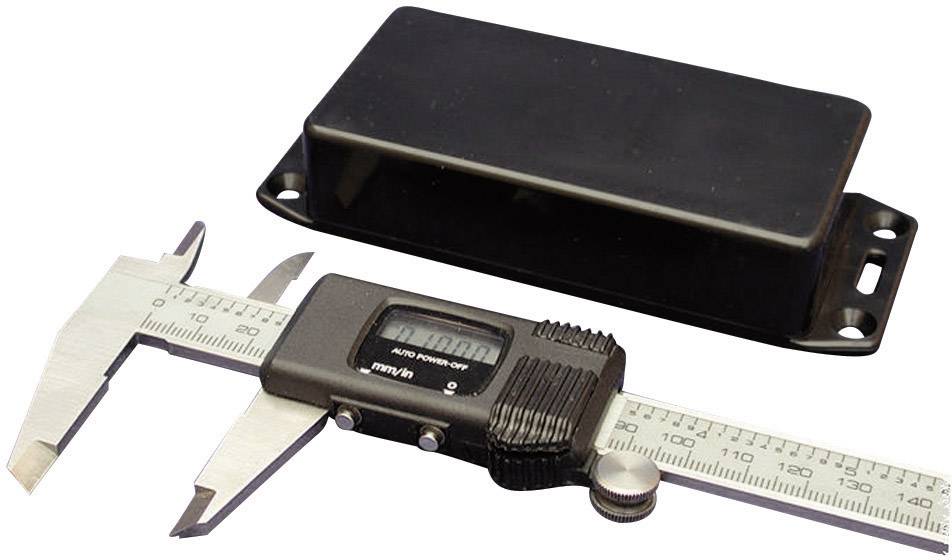 A digital calliper lies beside a black rectangular housing. The calliper displays a measurement.