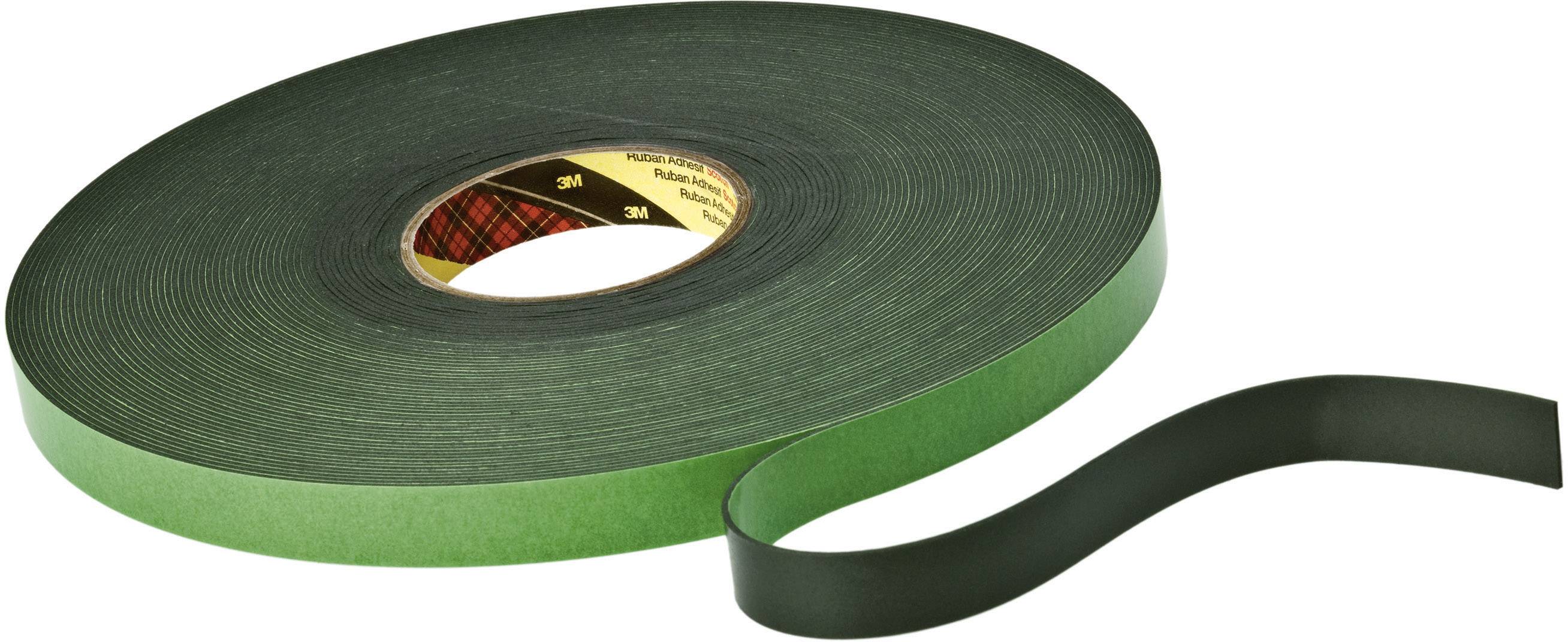 A green double-sided adhesive tape rolled up; one end is loose and shows the black adhesive surface.