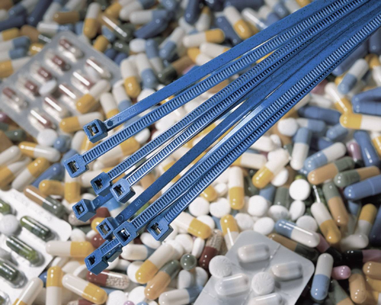 A blue cable tie lies on a variety of colourful pills and tablet blister packs.