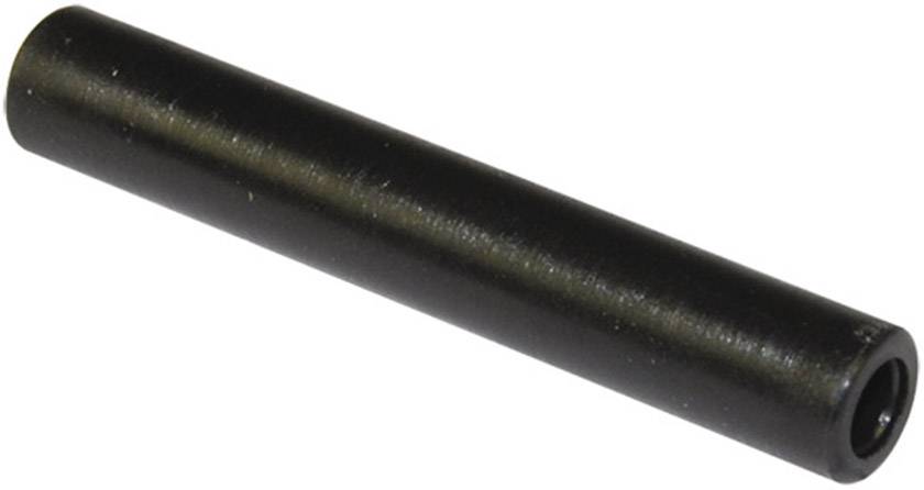 A black, cylindrical metal pin lies diagonally, pointing from bottom left to top right.