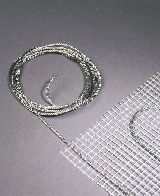 A wire reel lies beside a piece of wire mesh on a grey surface. The wire symbolises connectivity.