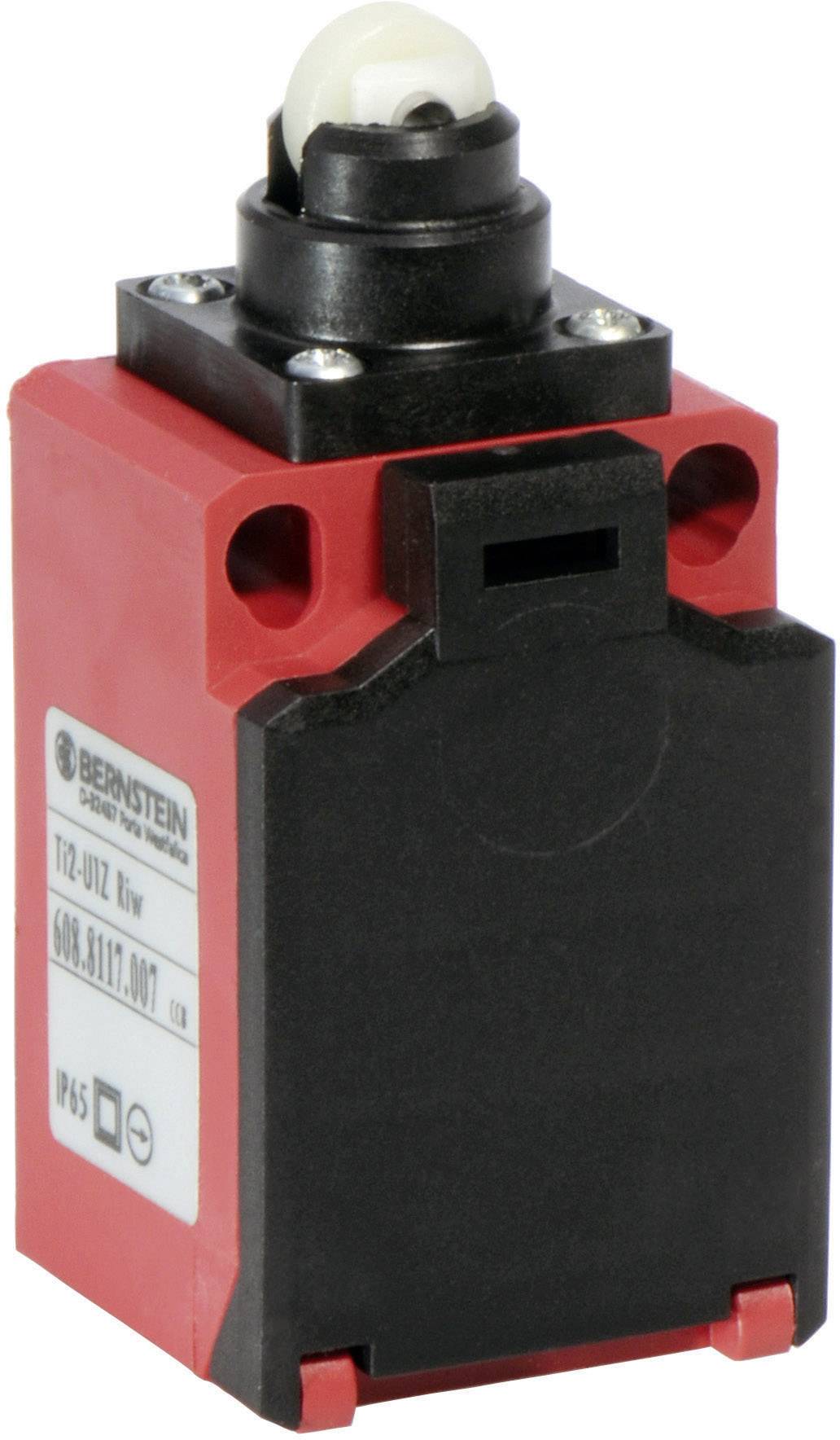 Red emergency stop switch with a black head and white actuating element. A label with technical details is visible on the housing.