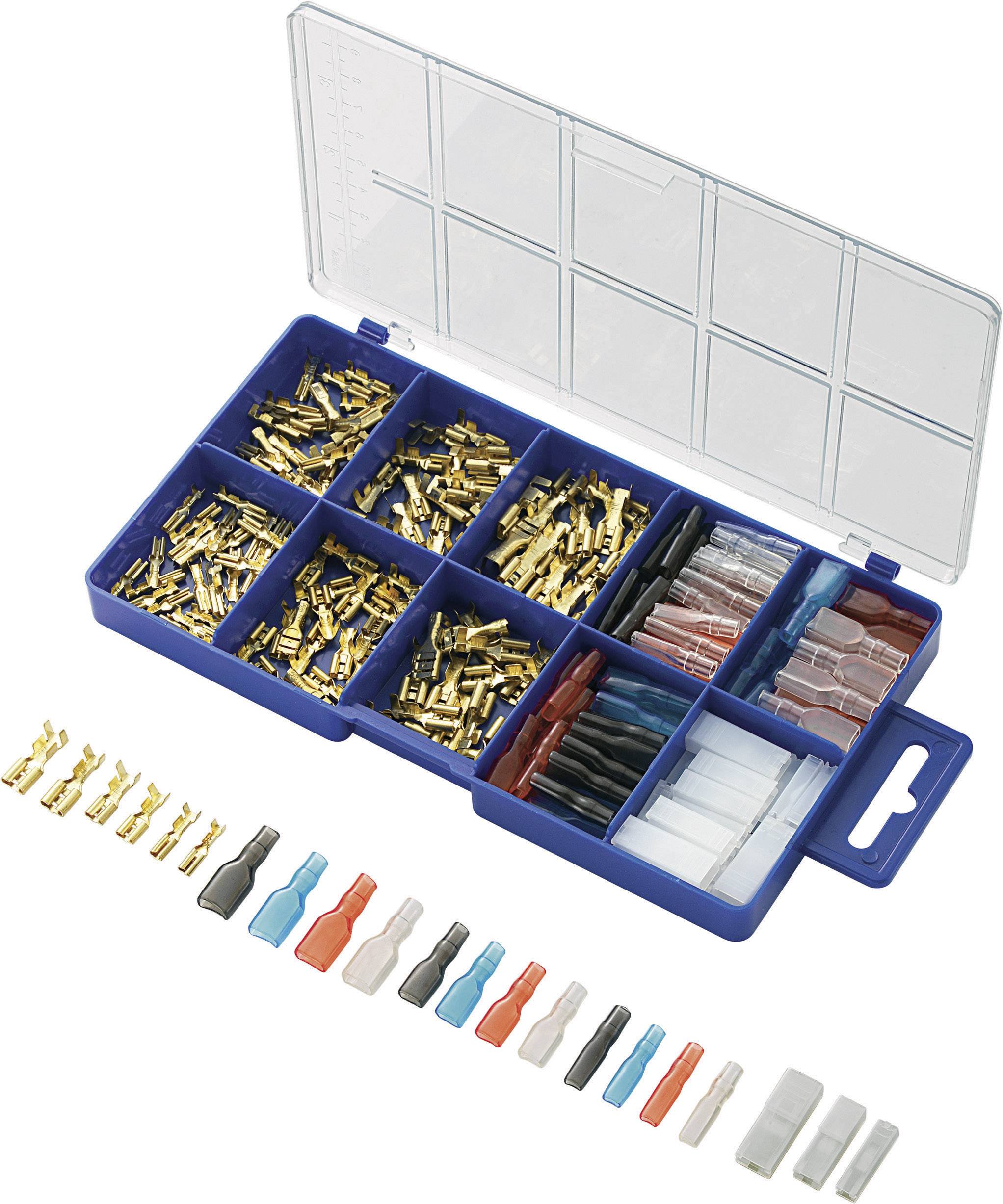 A blue box with open compartments contains various plugs and terminals in gold and silver. Coloured terminals are laid out in front of the box.