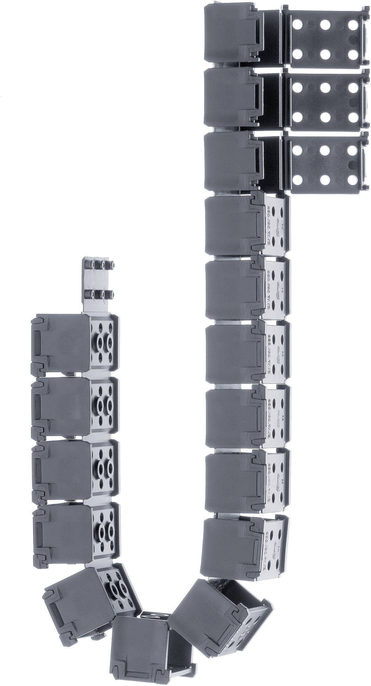 Several black, rectangular plastic modules, connected by hinges, form a flexible chain. They are lying on a light background.