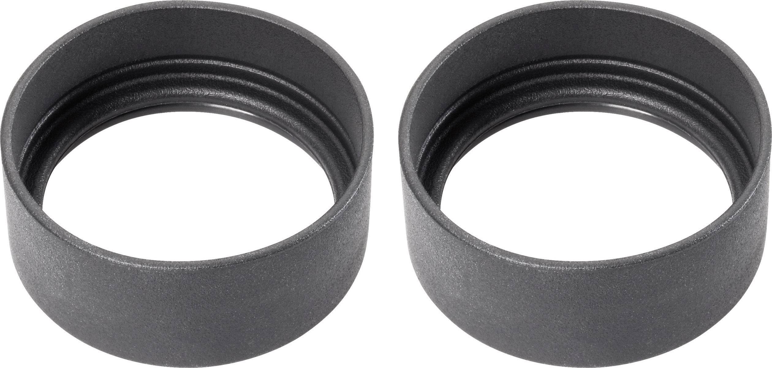 Two black plastic lens caps lying side by side. They are open and showing their inner side.