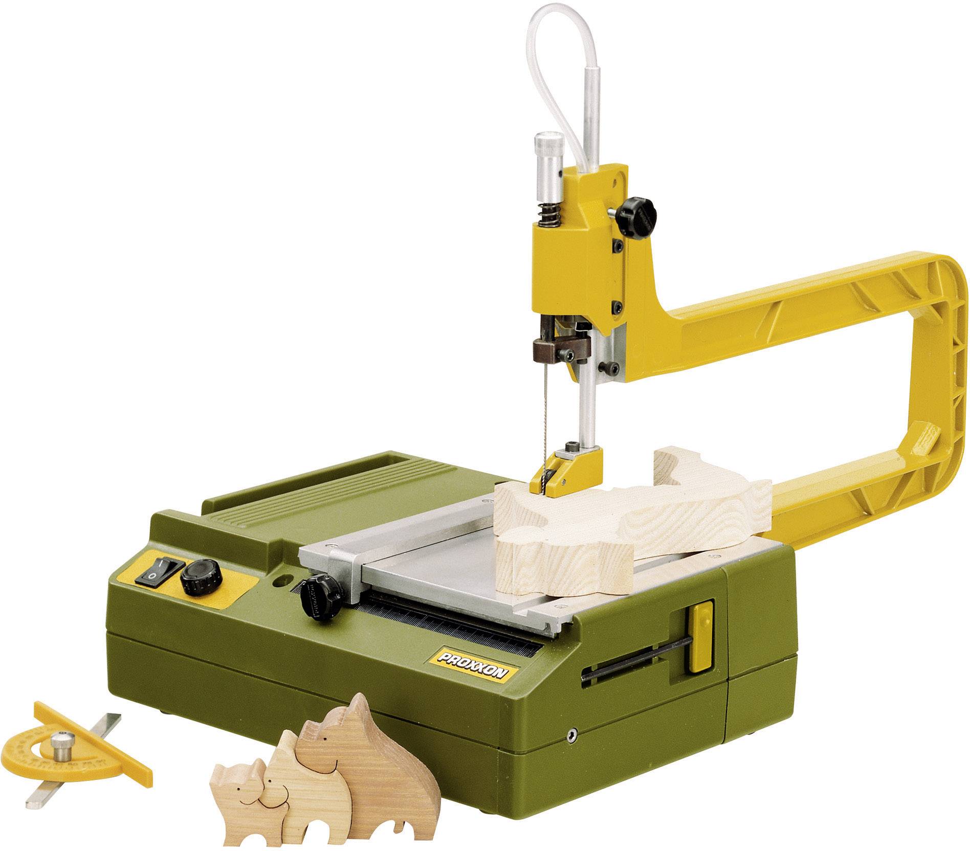 An electric jigsaw with a yellow arm is cutting wood into the shape of a rhinoceros. Two more wooden figures are standing beside it.