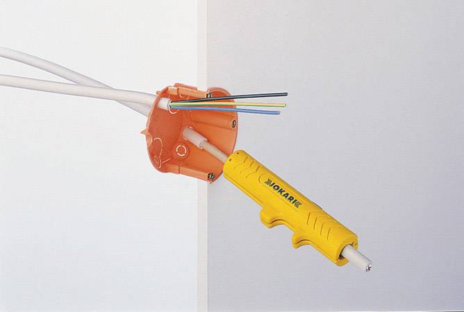 'Tool cuts cable' into the wall socket. Yellow tool holds several cables protruding from an orange socket.