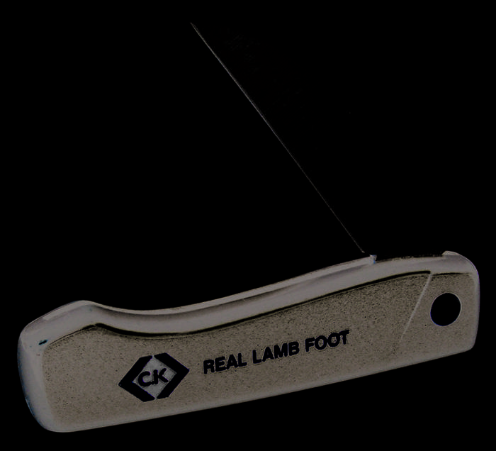 Black pocket knife with yellow lettering 'CK REAL LAMB FOOT'. Blade partially open, handle with round, yellow rivet head.