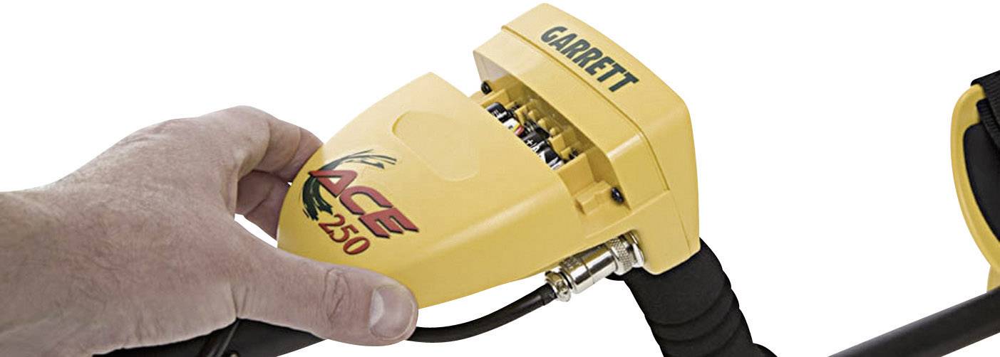 A hand is holding the yellow metal detector 'Garrett ACE 250'.