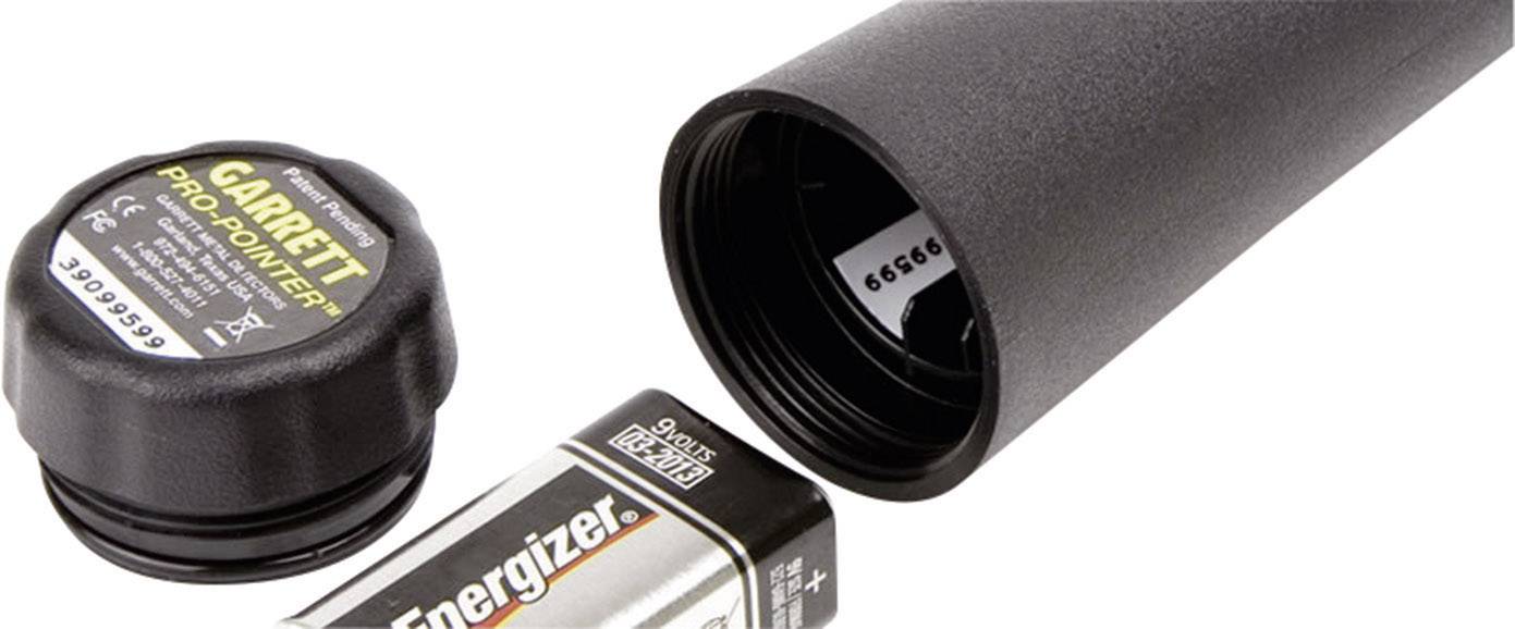 Black metal detector, battery compartment open, showing an 'Energizer' battery and a black protective cap with 'Garrett Pro-Pointer' inscription.