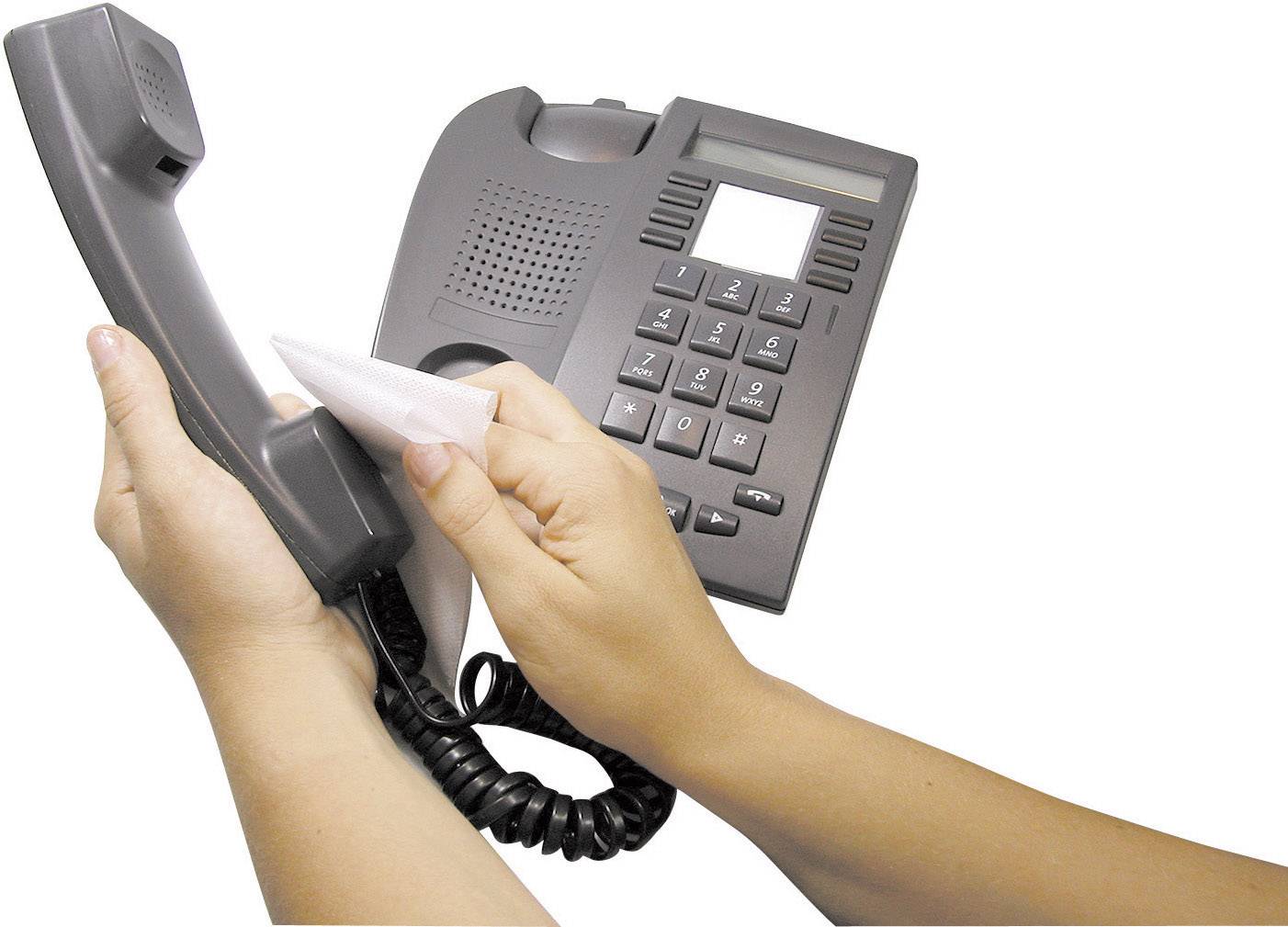 Someone is cleaning a grey telephone with a cloth while holding the receiver.