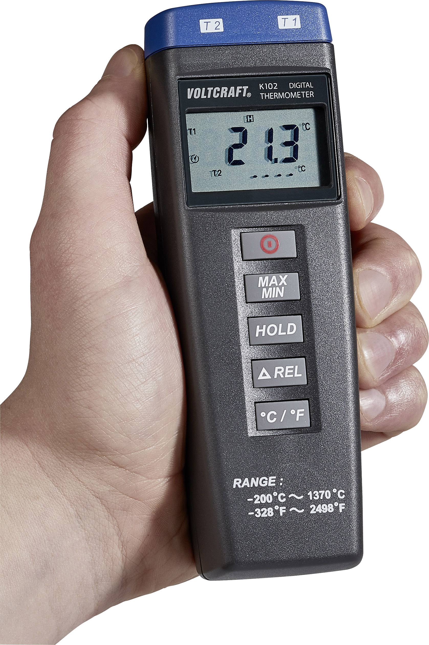 Une main tient un thermomètre numérique dont l'affichage indique 21,3 degrés Celsius. Des touches permettent de sélectionner Max/Min, Hold, Rel, °C/°F et la plage de température.