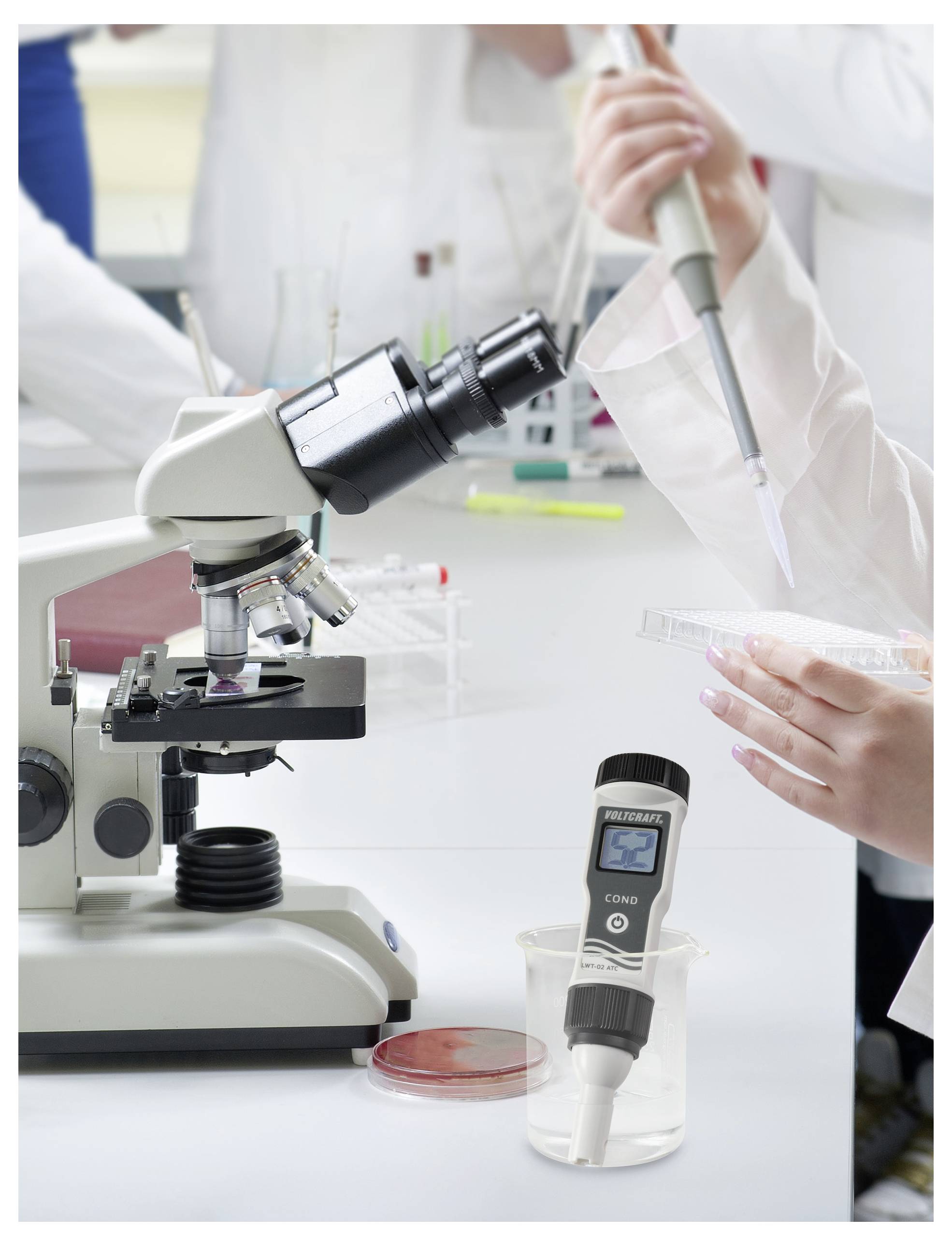 Un environnement de laboratoire avec un microscope, des mains utilisant une pipette, et un appareil numérique affichant « 2,00 ».