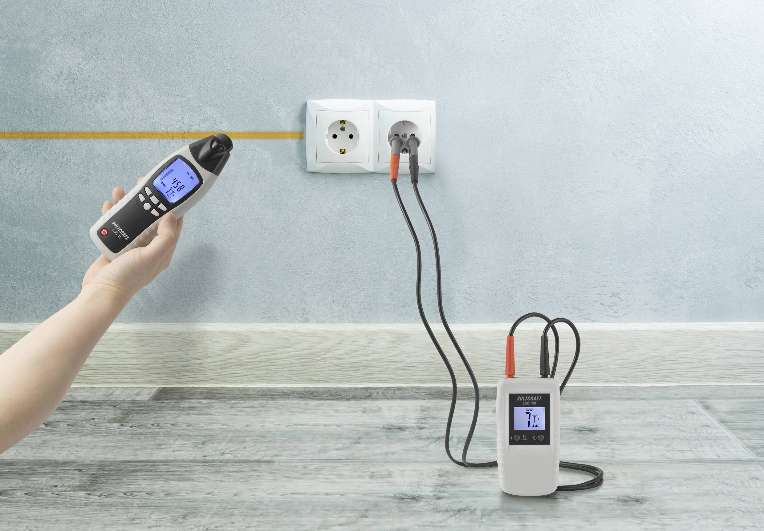 Une personne utilise un appareil de mesure numérique pour vérifier l'efficacité énergétique d'une prise électrique. Un autre appareil effectue des mesures en parallèle.