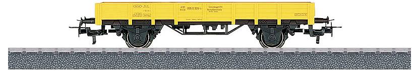 Un wagon de marchandises jaune sur des rails, vu de côté, avec des détails de roues et des composants mécaniques visibles en dessous.