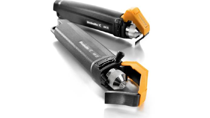 Deux outils électriques noirs avec des touches orange sont posés sur une surface blanche, l'un montrant sa pointe, l'autre son dos.