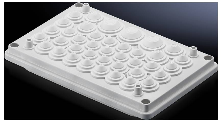 Un insert en plastique blanc avec plusieurs protubérances circulaires de différentes tailles sur un fond sombre.
