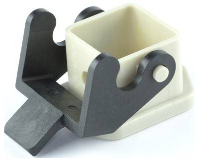 Pince noire maintenant une tasse ou un récipient carré beige sur un support de base blanc, montré sur un fond neutre.