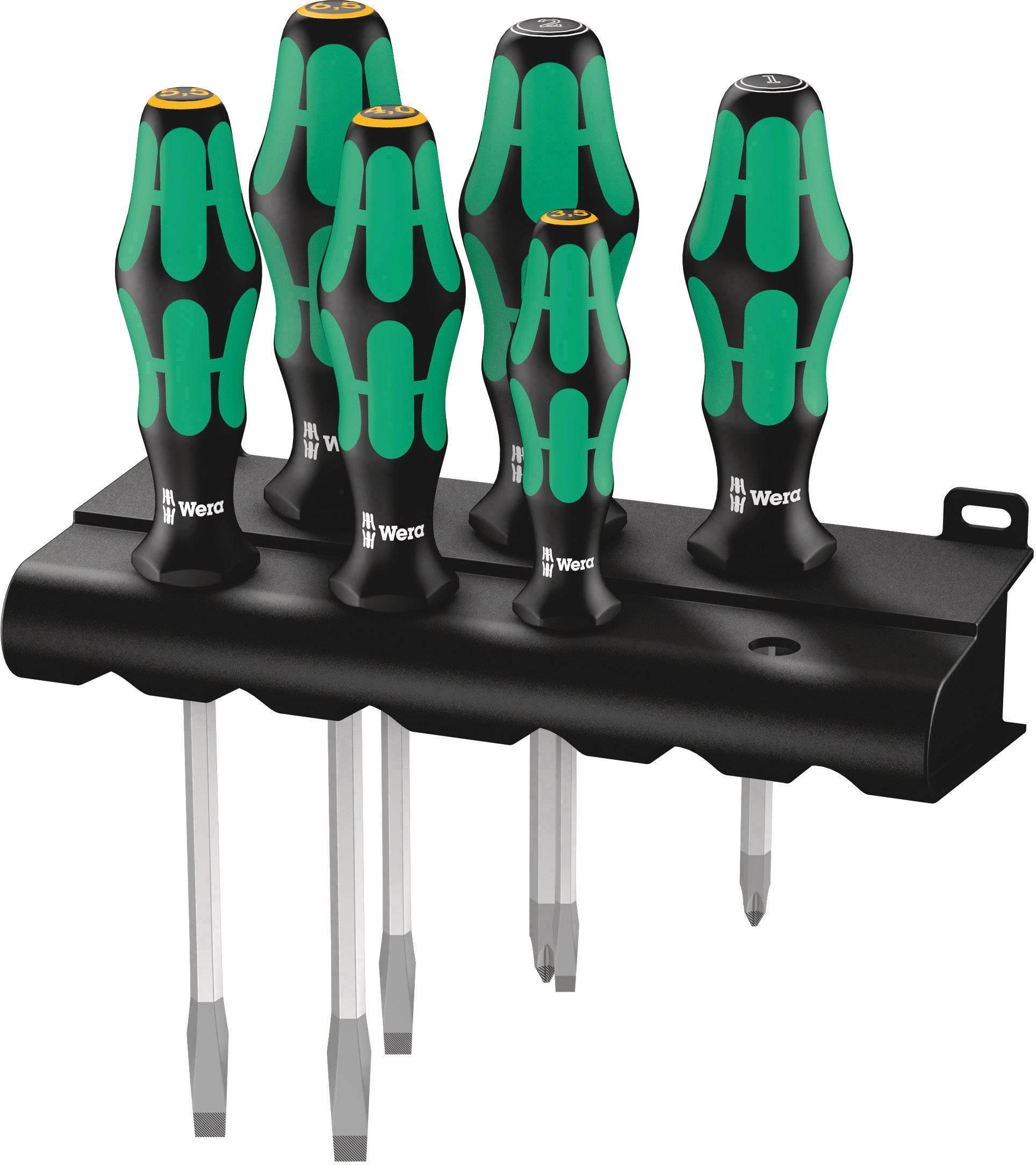 Six tournevis verts et noirs avec des poignées ergonomiques rangés sur un support noir, pour un rangement ordonné.