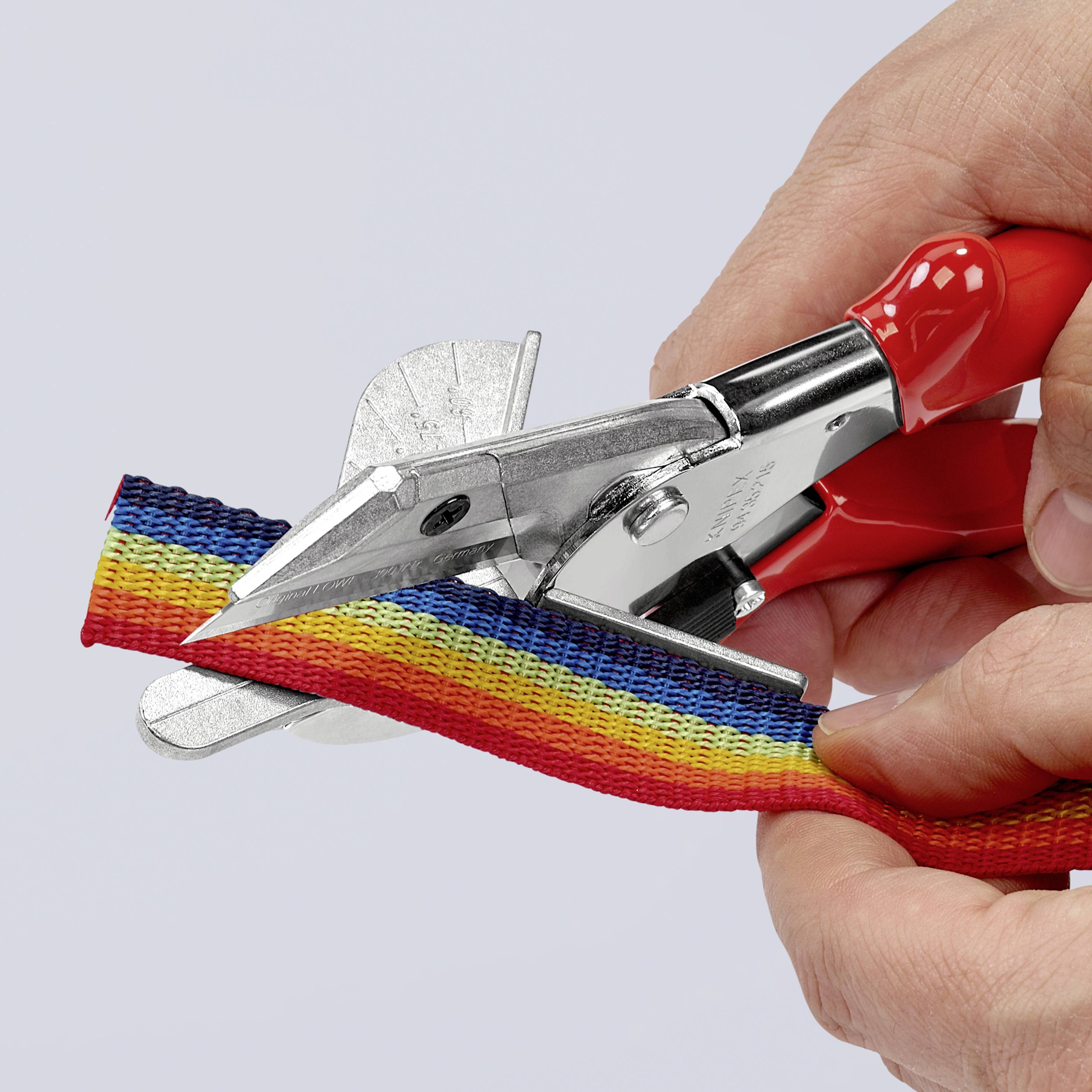 Une main coupe un ruban arc-en-ciel avec des ciseaux rouges.