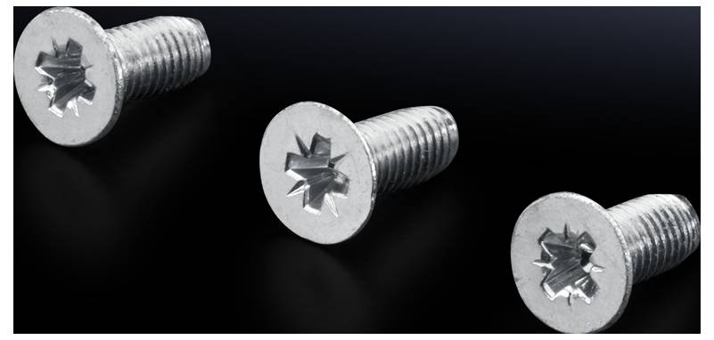 Trois vis argentées à têtes étoilées reposent sur une surface noire.