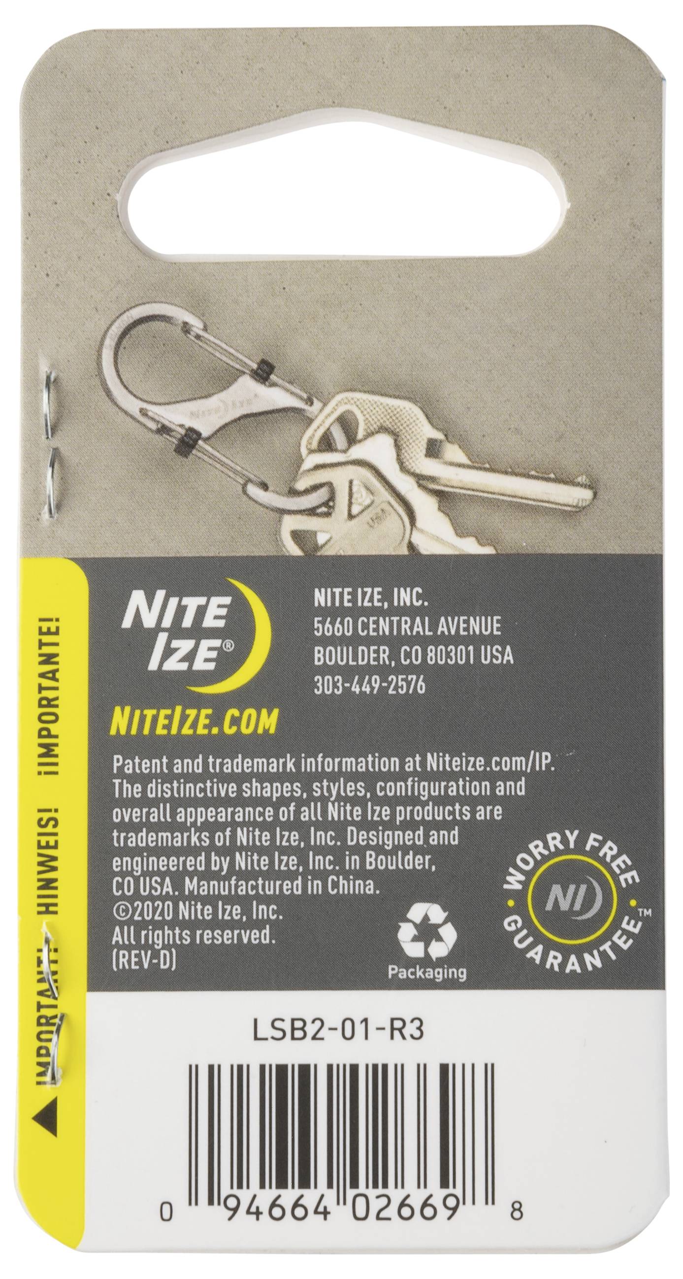 Un badge de produit Nite Ize présentant un porte-clés avec des informations de contact, un site web et un badge de 'Garantie sans soucis' ; montre un mousqueton avec des clés.