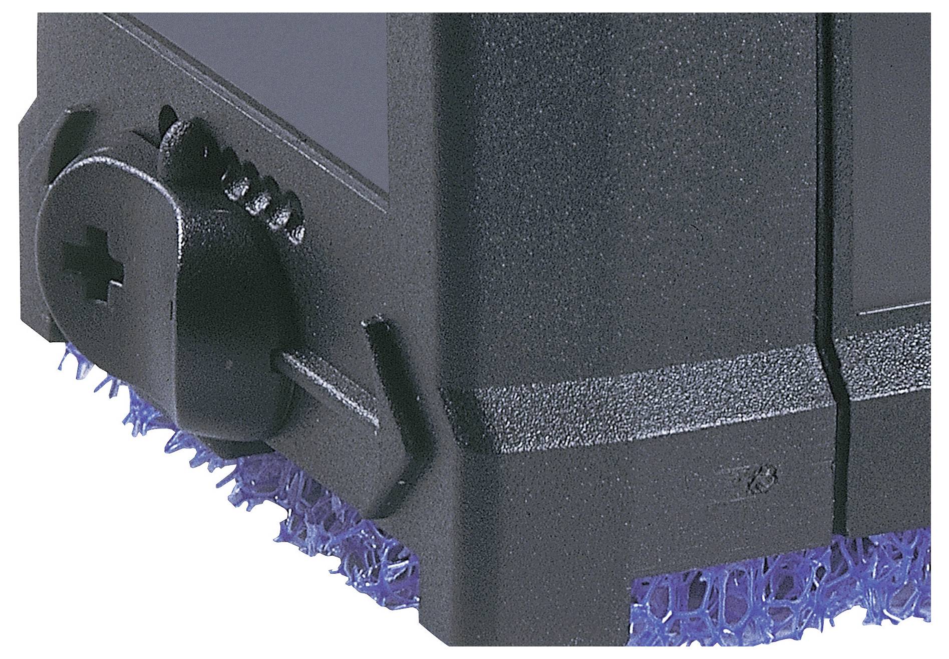 Vue rapprochée d'un dispositif électronique noir mettant en valeur un cadran rotatif et une surface texturée bleue en dessous, probablement destinée au refroidissement ou à la ventilation.