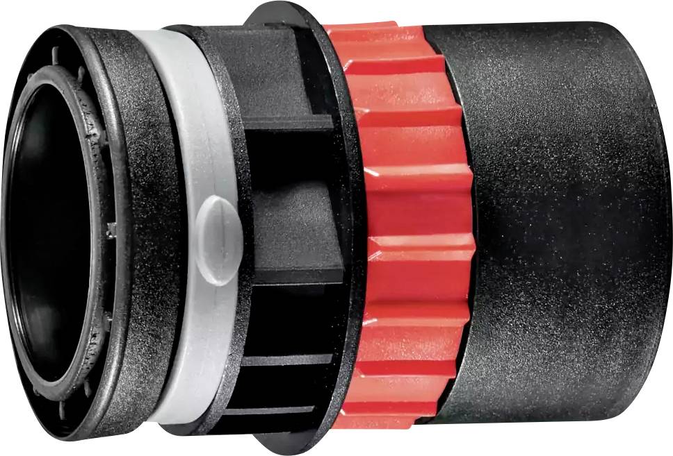 Un gros plan d'un connecteur mécanique ou d'un coupleur en plastique noir et rouge, montrant ses sections filetées et un design rainuré et nervuré.