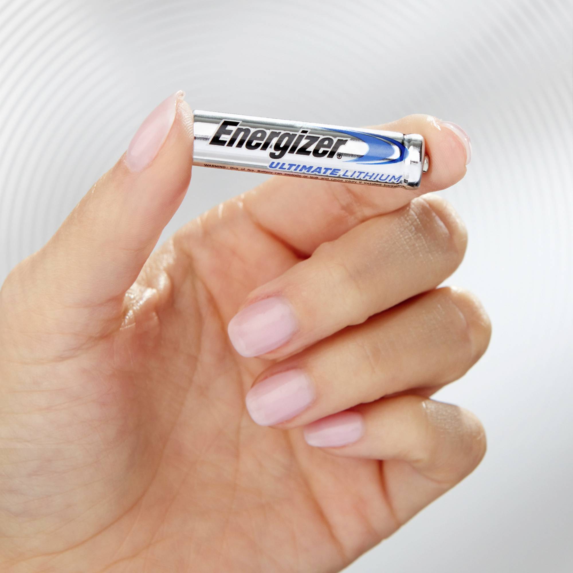 Une main tient une pile Energizer Ultimate Lithium entre le pouce et l'index.