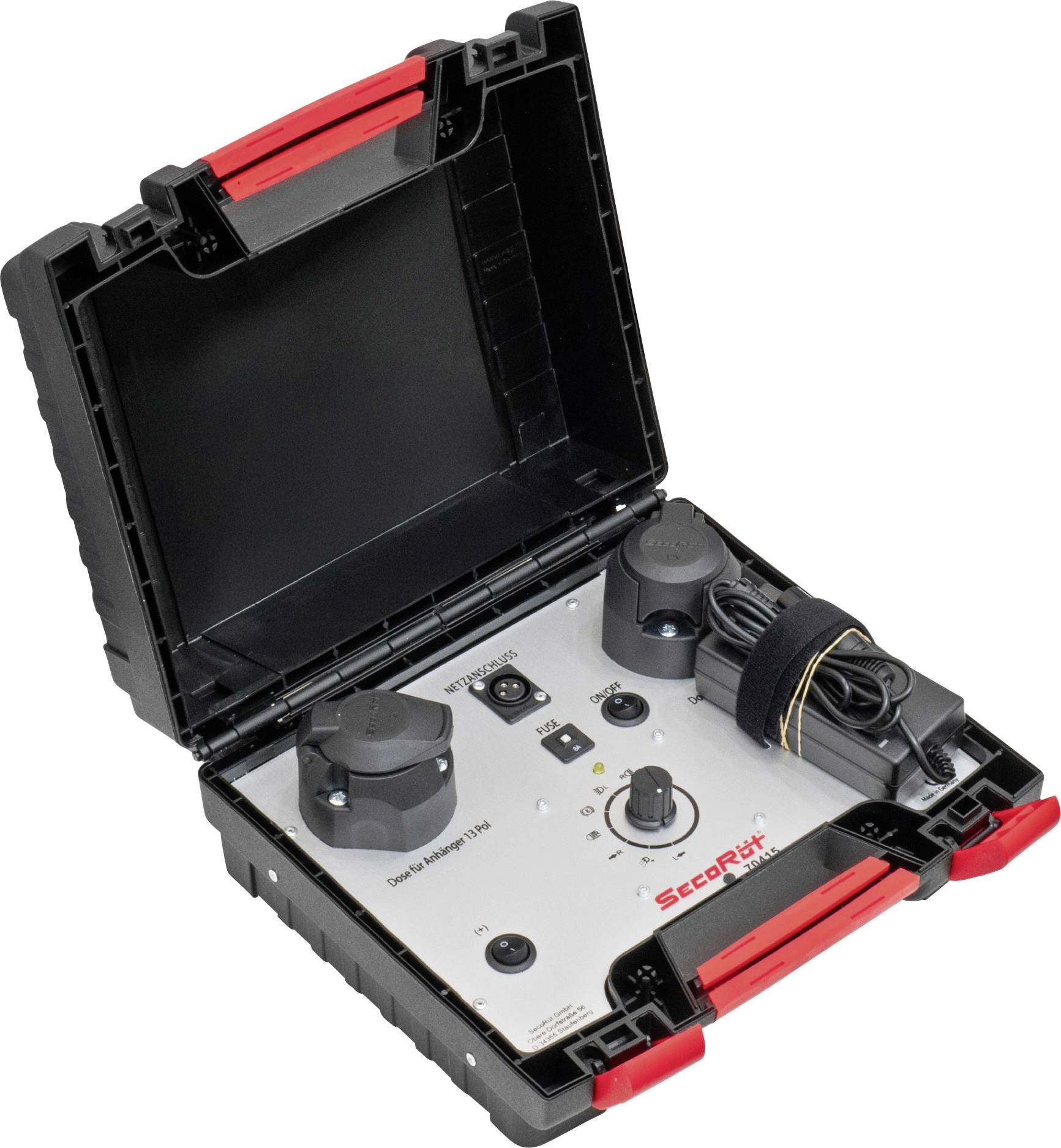 Valise noire ouverte contenant du matériel technique ; montre des boutons rotatifs, un écran et un faisceau de câbles enroulé à l'intérieur.