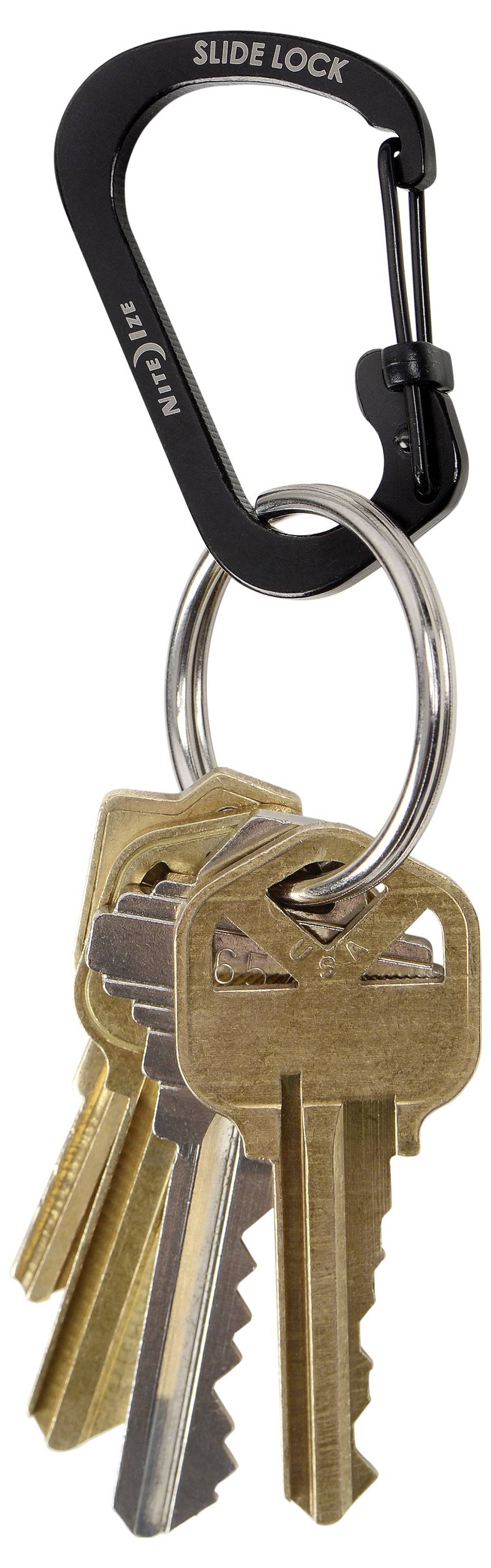 Un mousqueton noir portant le texte « Slide Lock » retient un anneau de clés en laiton.