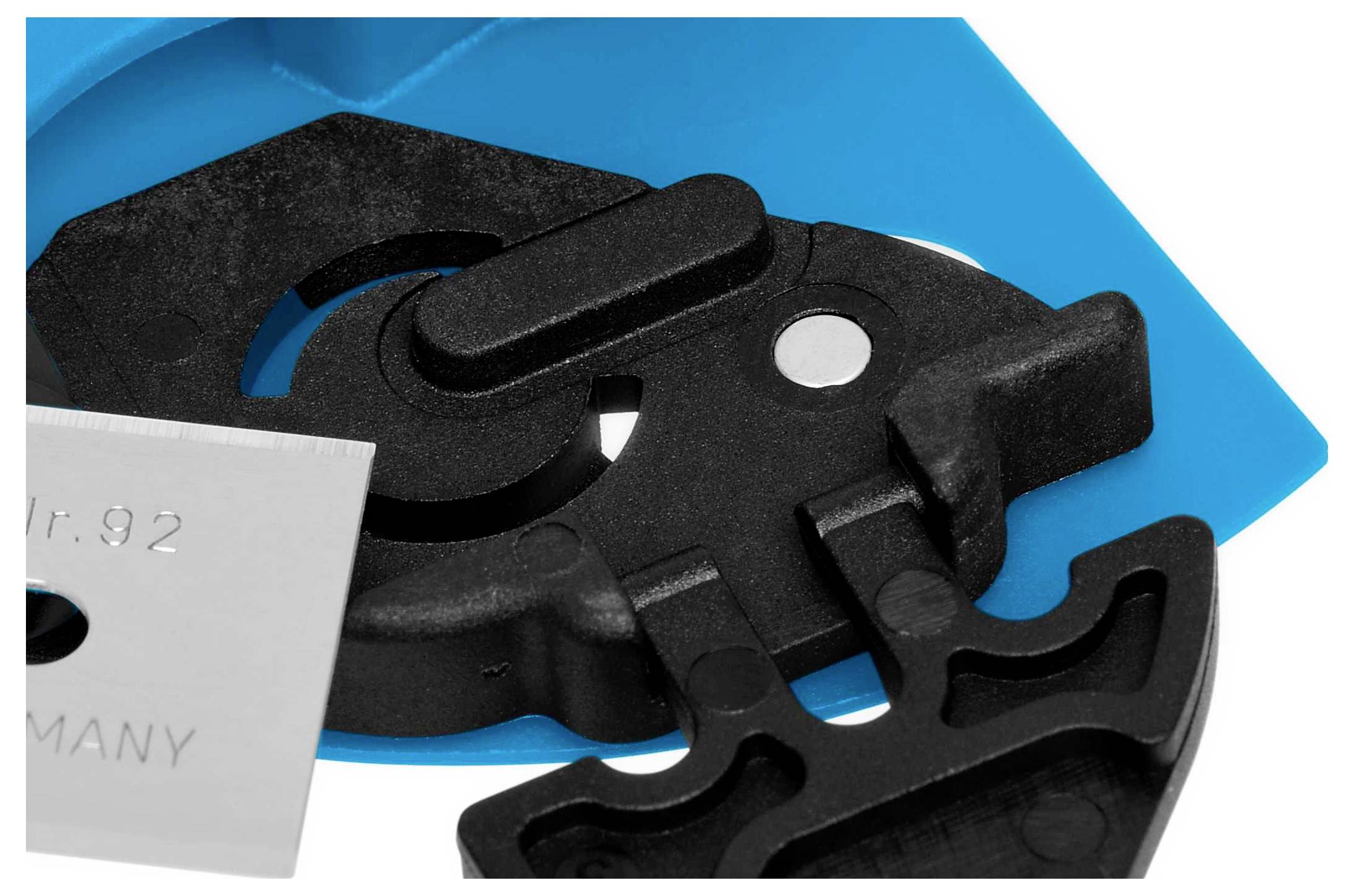 Une pièce en plastique bleu et noir avec un insert métallique de lame, probablement un composant d'un dispositif de coupe ou d'un outil.