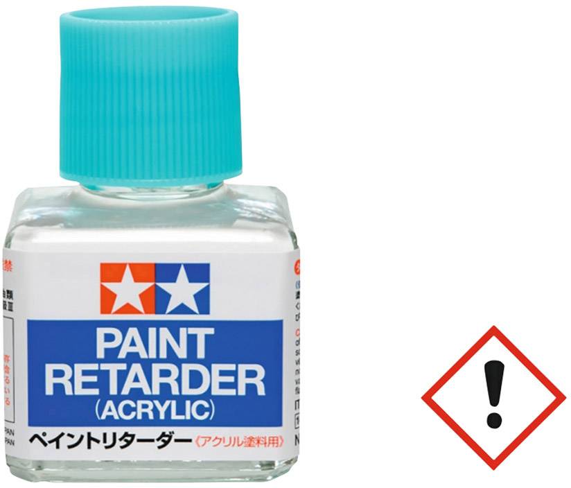 Bouteille avec étiquette bleue portant l'inscription 'Paint Retarder (Acrylique)'. Un symbole de danger rouge avec un point d'exclamation est visible.