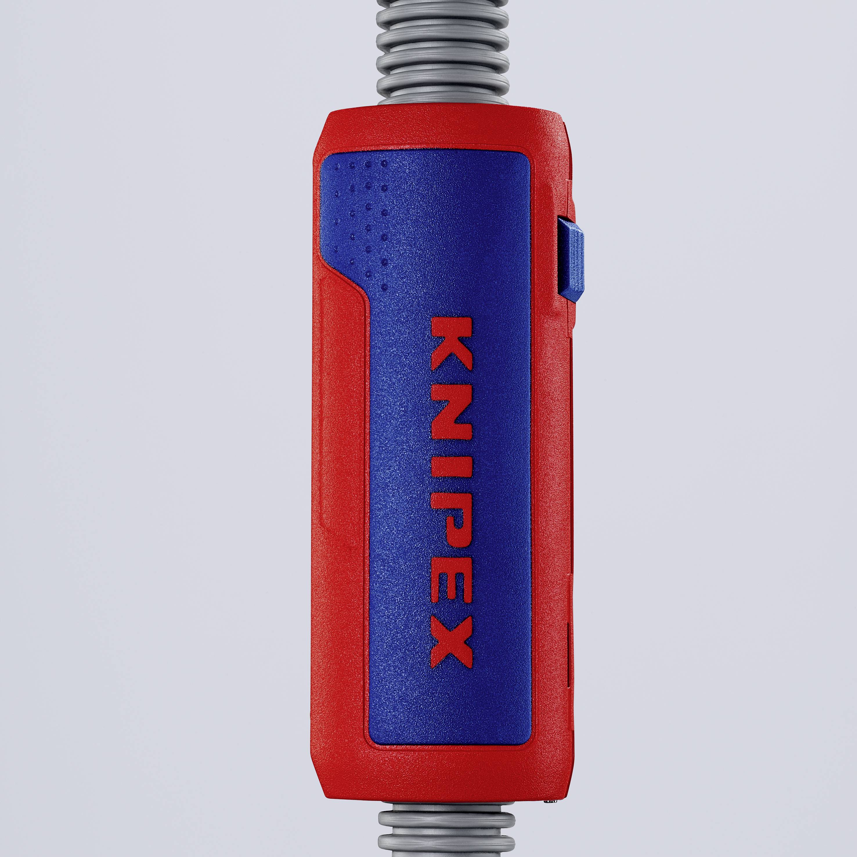 L'image montre une poignée rouge et bleue d'un outil portant l'inscription 'KNIPEX' au centre, adjacente à une spirale métallique.