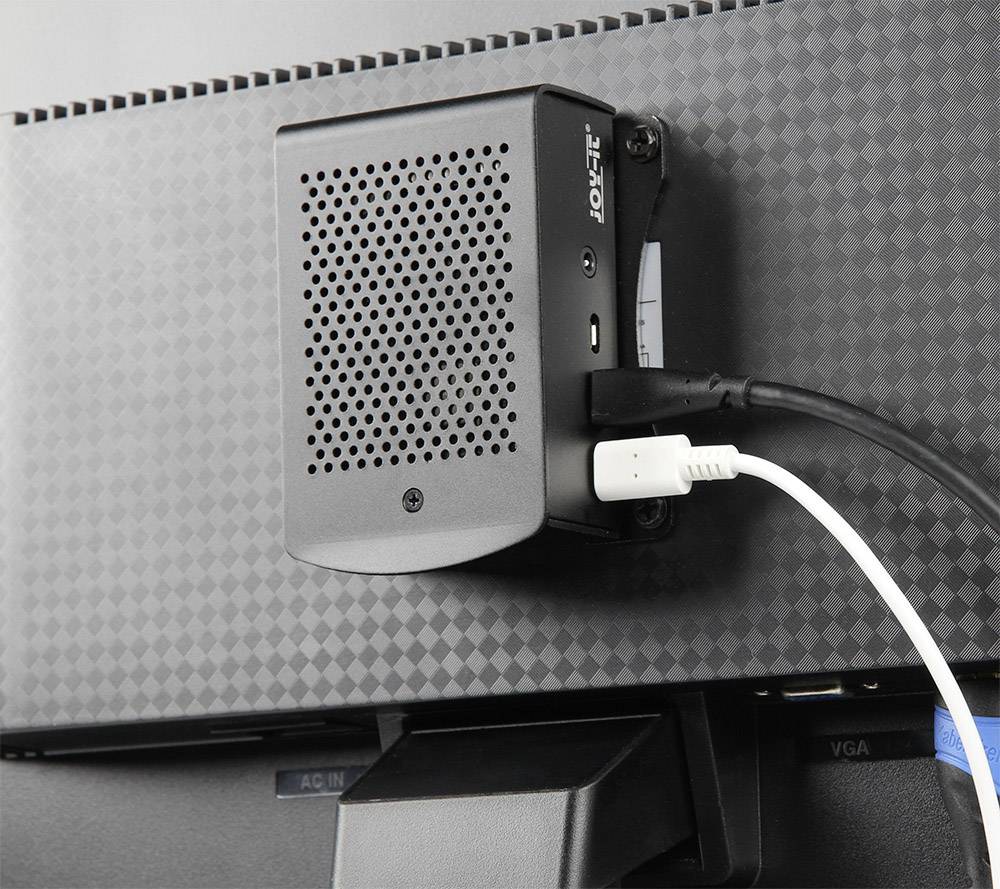 Un petit ordinateur est monté à l'arrière d'un moniteur. Un câble USB est connecté à l'ordinateur.