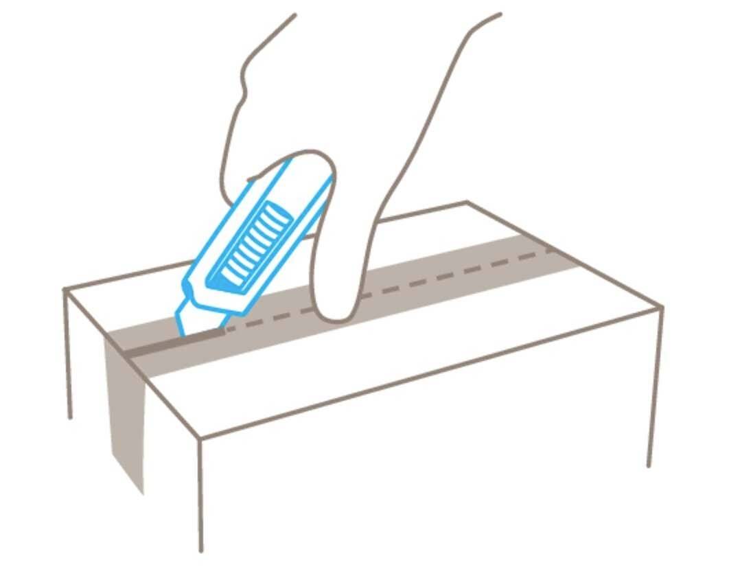 Une main coupe un ruban adhésif avec un couteau utilitaire sur un carton pour l'ouvrir.