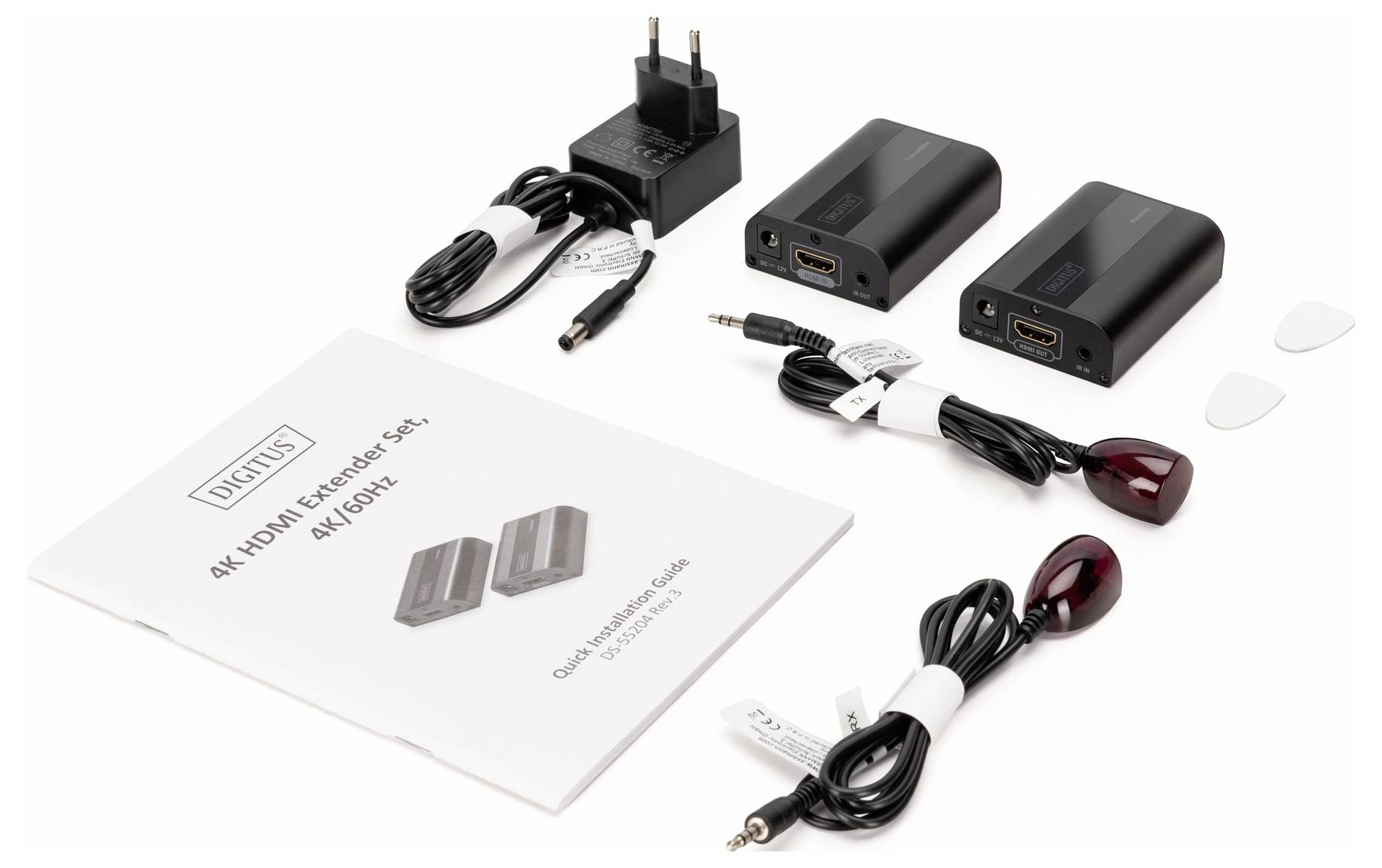 Un ensemble d'extendeurs HDMI comprenant un manuel, deux appareils noirs, un bloc d'alimentation, deux récepteurs infrarouges et deux câbles.