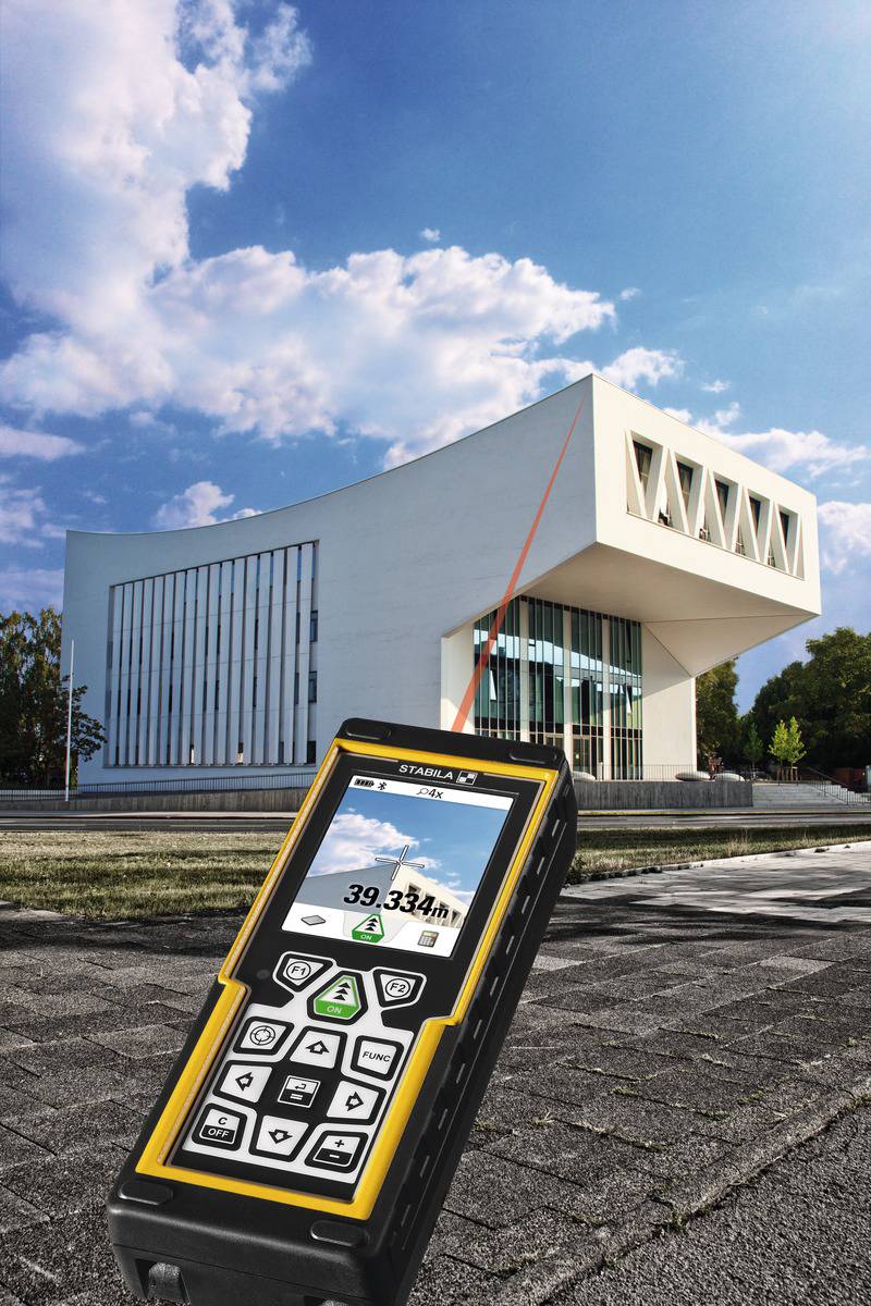 Un télémètre laser indique la distance jusqu'à un bâtiment moderne, blanc, doté de grandes fenêtres, avec un ciel bleu en arrière-plan.