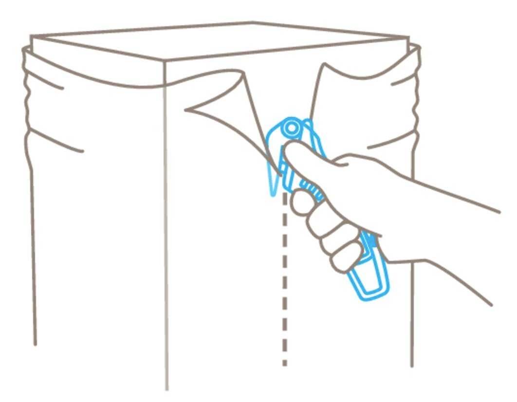 Une main utilise un cutter pour ouvrir un colis le long d'une ligne pointillée.