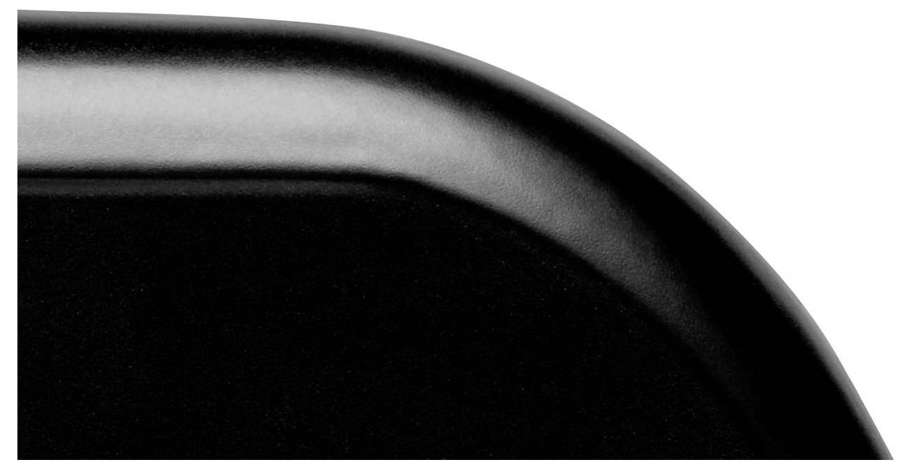 Coin d'un objet rectangulaire noir à bord arrondi, gros plan.