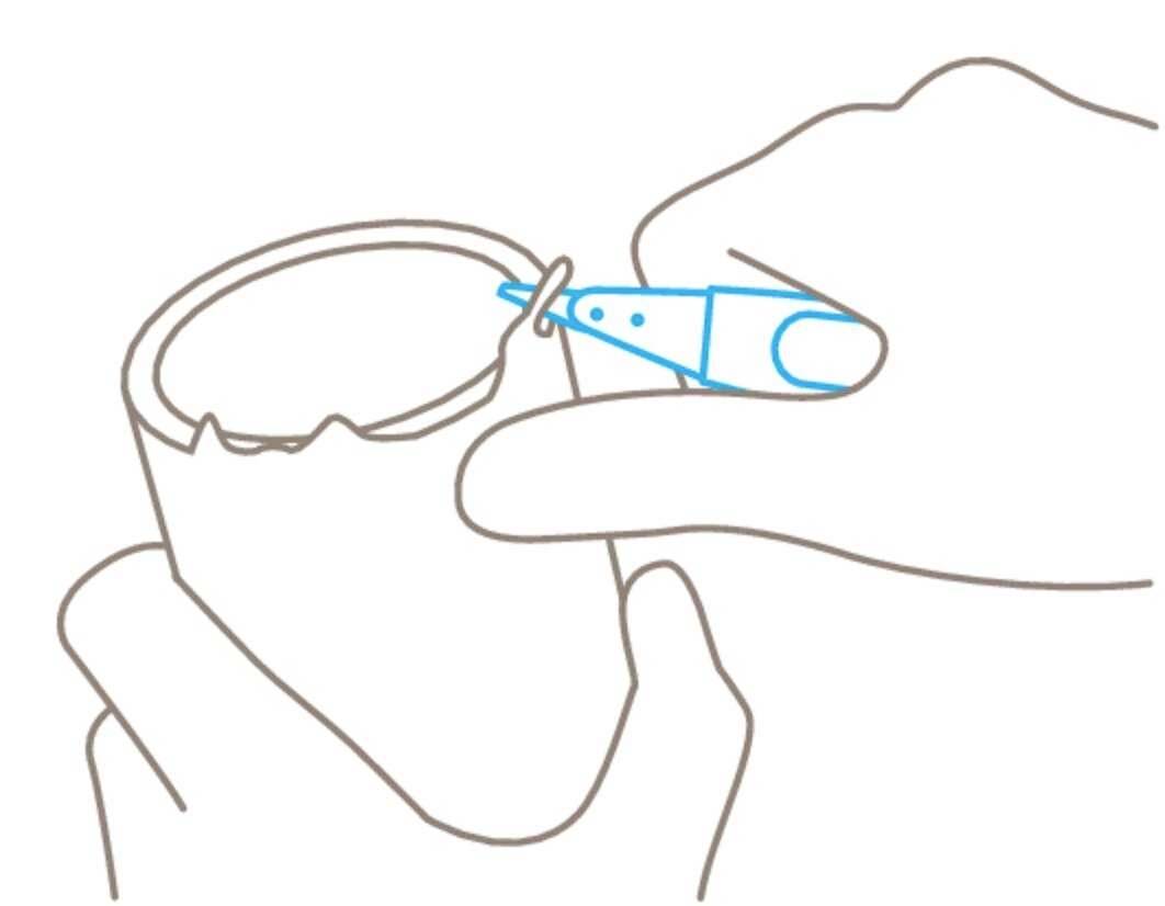 Mode d'emploi illustré : Une main tient un stylo le long du bord intérieur d'un gobelet, probablement pour le marquer.